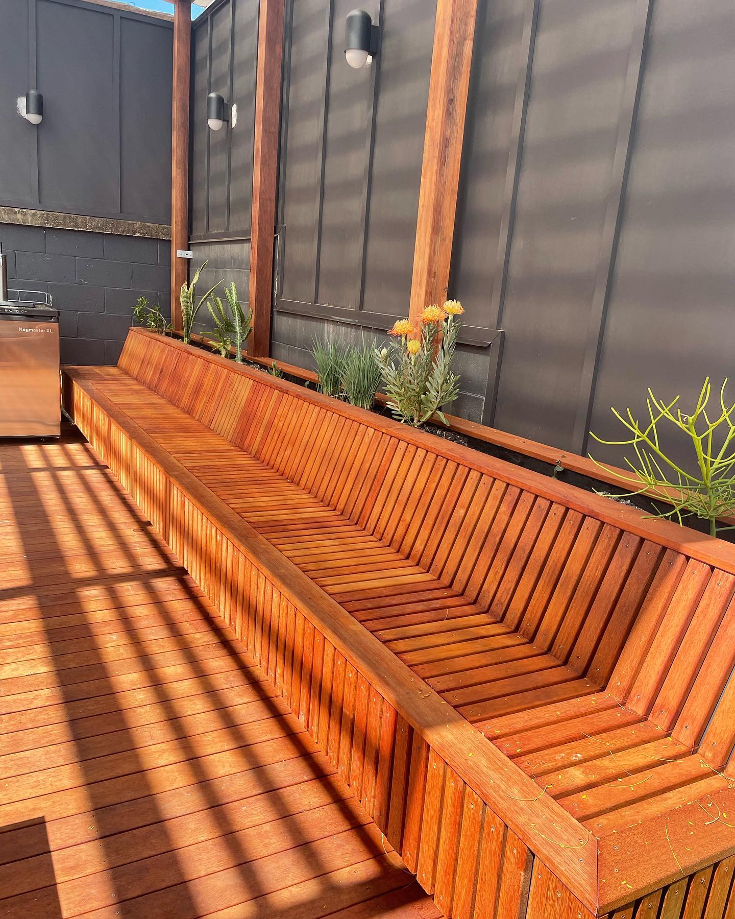 Built-in Deck Seating: Hardwood bench seat and planter built into a sun-filled deck.
