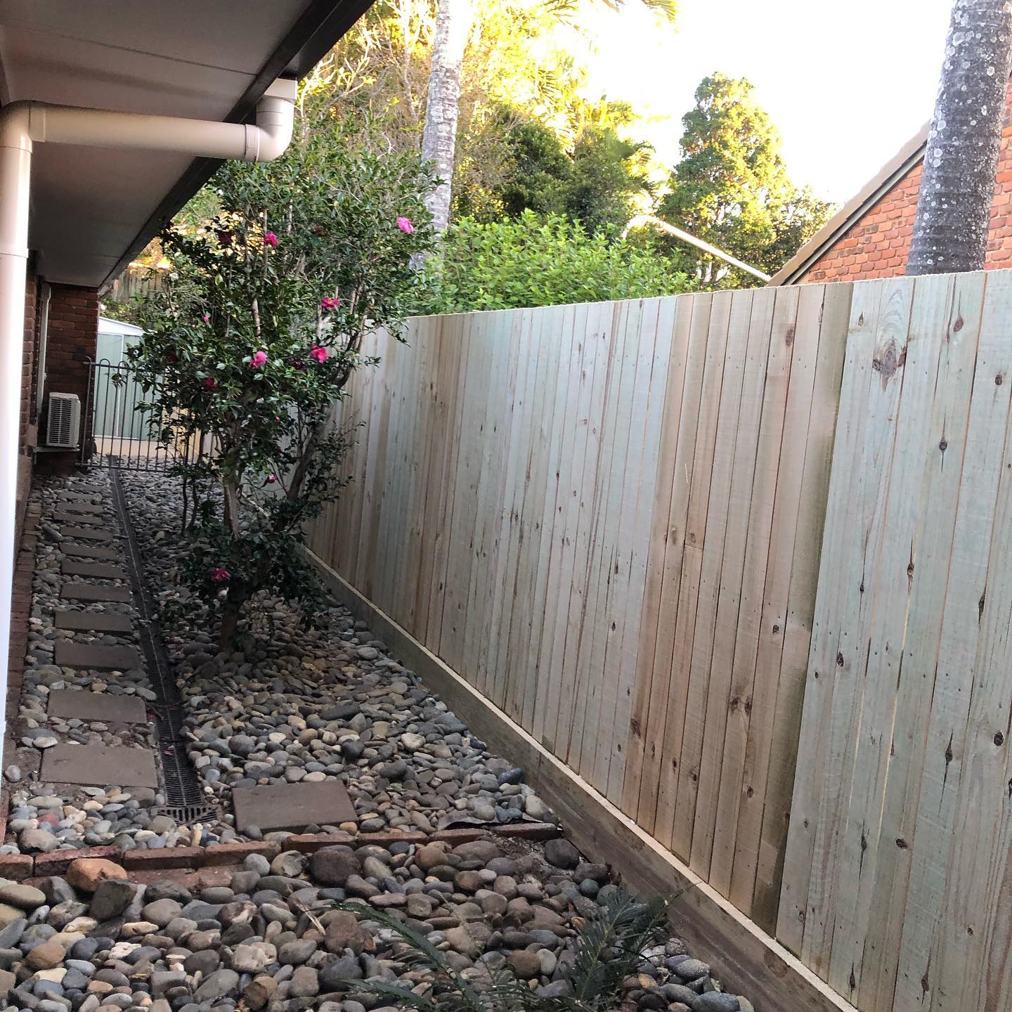 Boundary Fence & Landscaping: New timber paling fence with fresh garden beds and drainage.